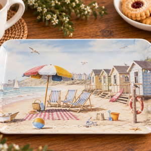 Plate with a beach scene: striped chairs, colorful umbrella, sand, and row of seaside huts by the water.